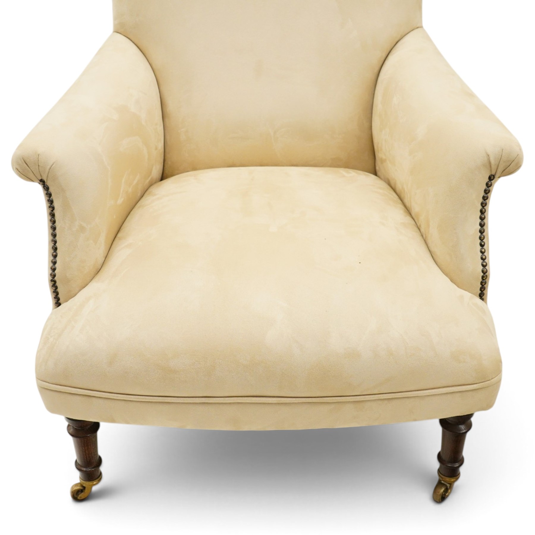 Sofas & Stuff - pair of ‘Thistle’ armchairs upholstered in neutral fabric, each with gently sloping back, padded scroll arms with close-set stud detailing, loose seat cushions, raised on turned wooden legs with brass castors