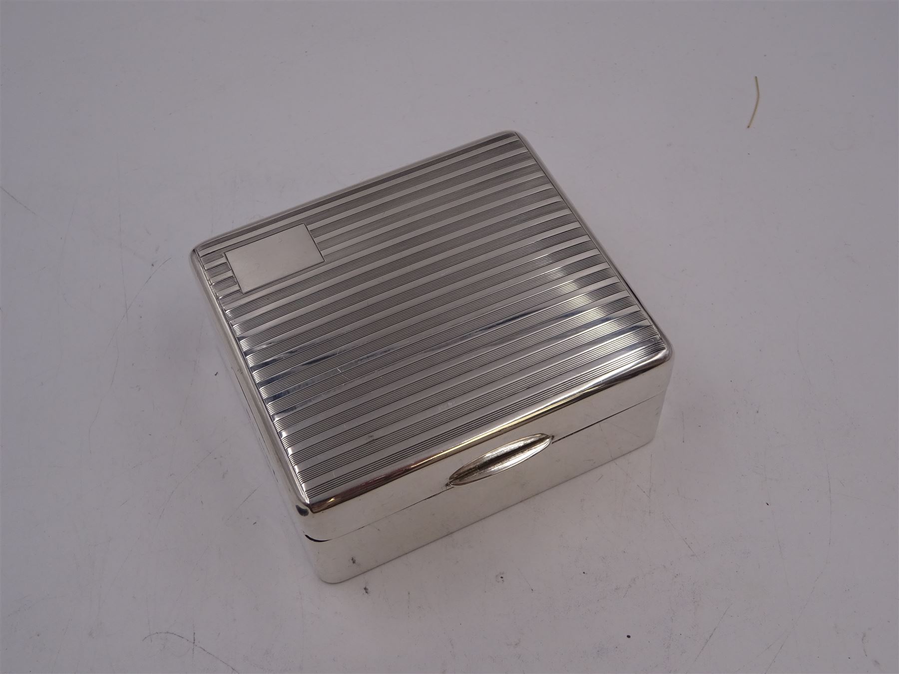 1930s silver mounted cigarette box, of square form, with engine turned decoration and blank rectangular panel to hinged cover, opening to reveal softwood lined interior, hallmarked William Neale & Son Ltd, Birmingham 1934, H3.8cm
