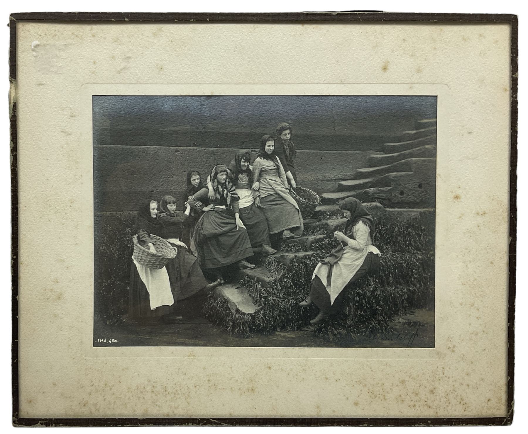 Frank Meadow Sutcliffe (British 1853-1941): Eight Fishergirls at the Foot of Whitby East Pier (E-6C), photograph signed in pencil, initialled and numbered FMS 450 in the image, original  FM Sutcliffe Whitby label verso 14cm x 19cm