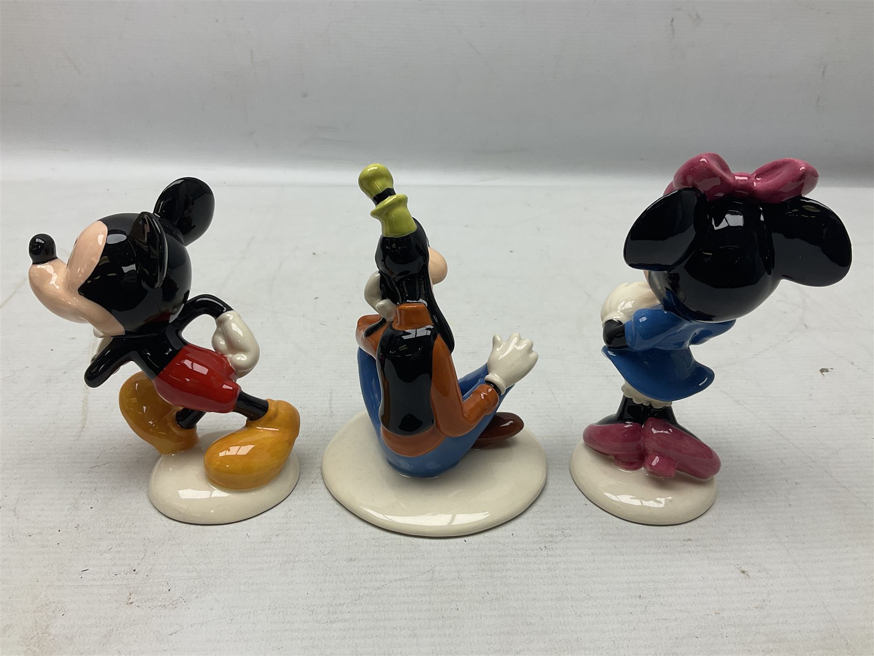 Three Royal Doulton The Mickey Mouse Collection figurines comprising Mickey Mouse MM1, Minnie Mouse MM2, and Goofy MM5, together withe three Royal Doulton limited edition miniature snowman character jugs comprising Christmas Stocking Snowman D7124, Christmas Cracker Snowman D7158 and Snowman D7062, all with original boxes 