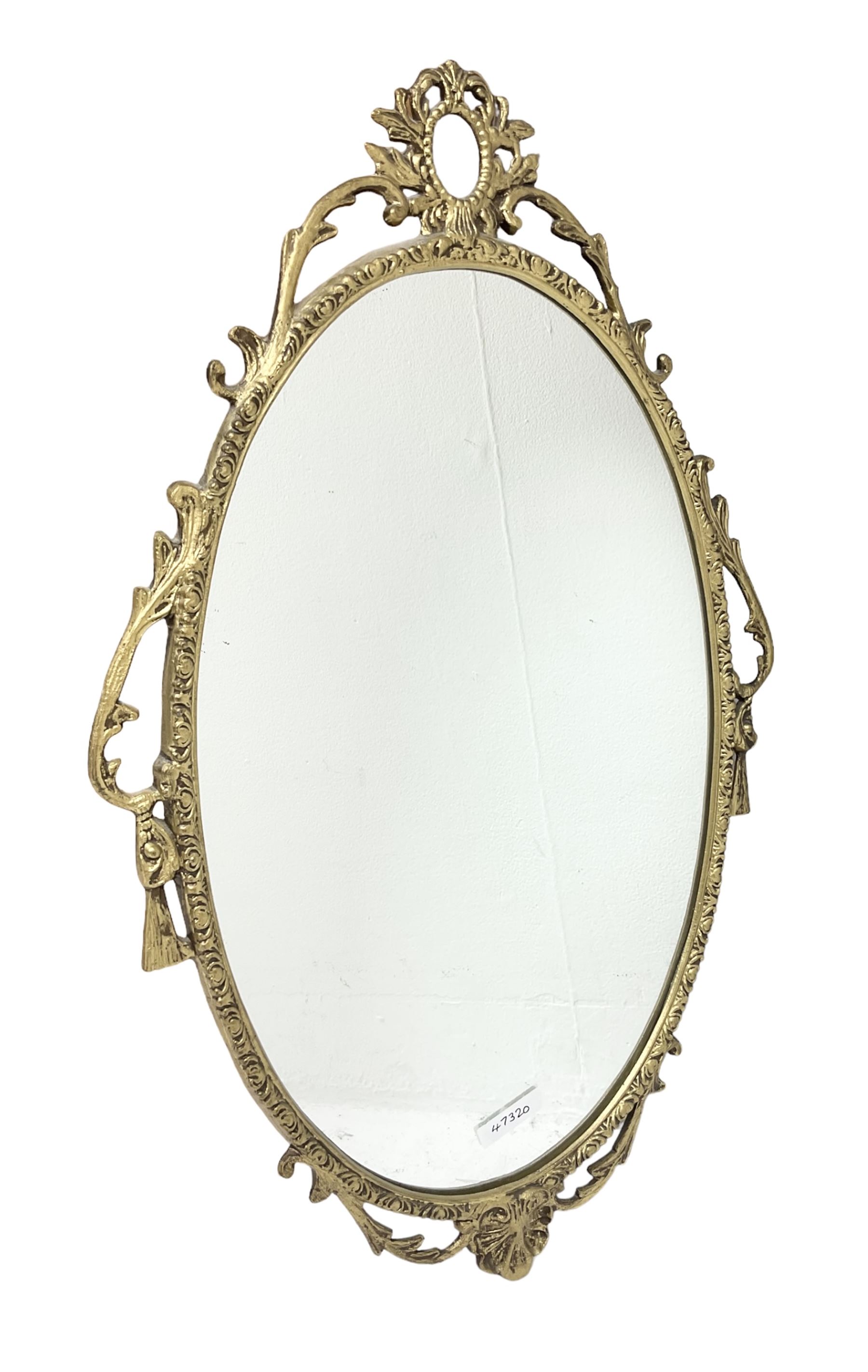 Ornate brass wall mirror with oval plate, L78cm
