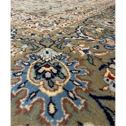 Central Persian Kashan hand-knotted carpet, ivory field with scrolling vines, palmettes, and rosettes around a cusped medallion with pendants and spandrels within a blue ground border of palmettes and flowerheads, 388cm x 300cm