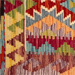 Afghan Chobi flatweave kilim, with a repeating stepped diamond medallion design in ivory, green, rust, teal, purple, indigo, and framed by chevron and geometric borders