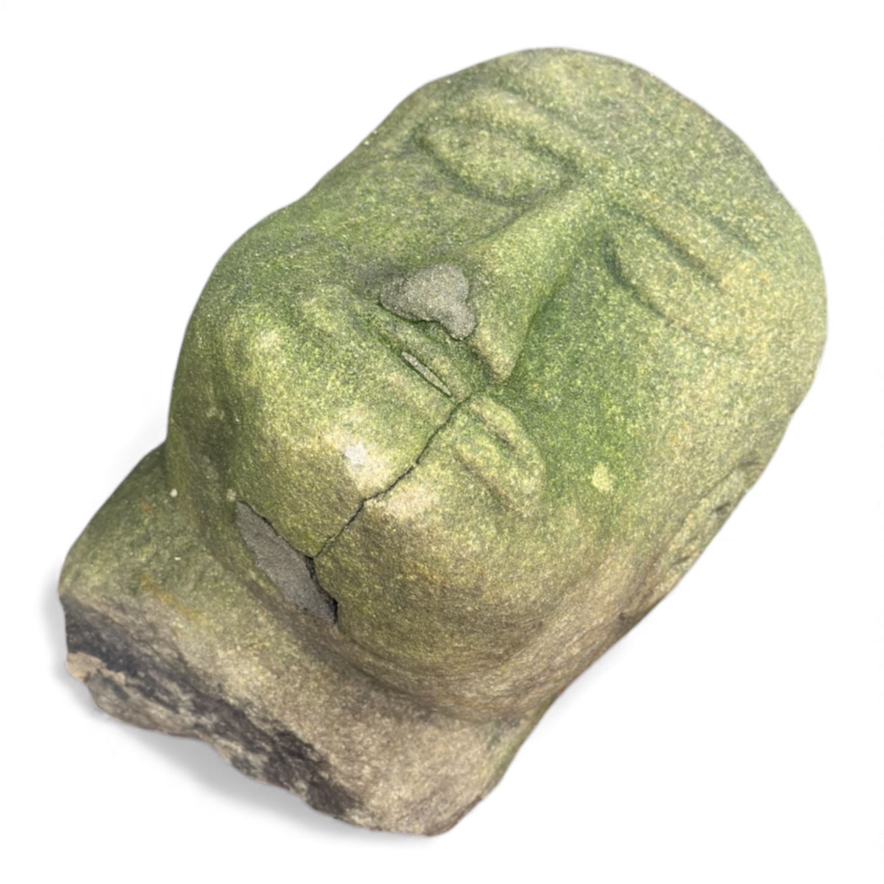 Collection of cast stone garden objects including mill stone, trough, planter, and faces