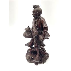 A Chinese carved hardwood figure, modelled as a fisherman with basket containing fish, with inset eyes and teeth, H25.5cm. 