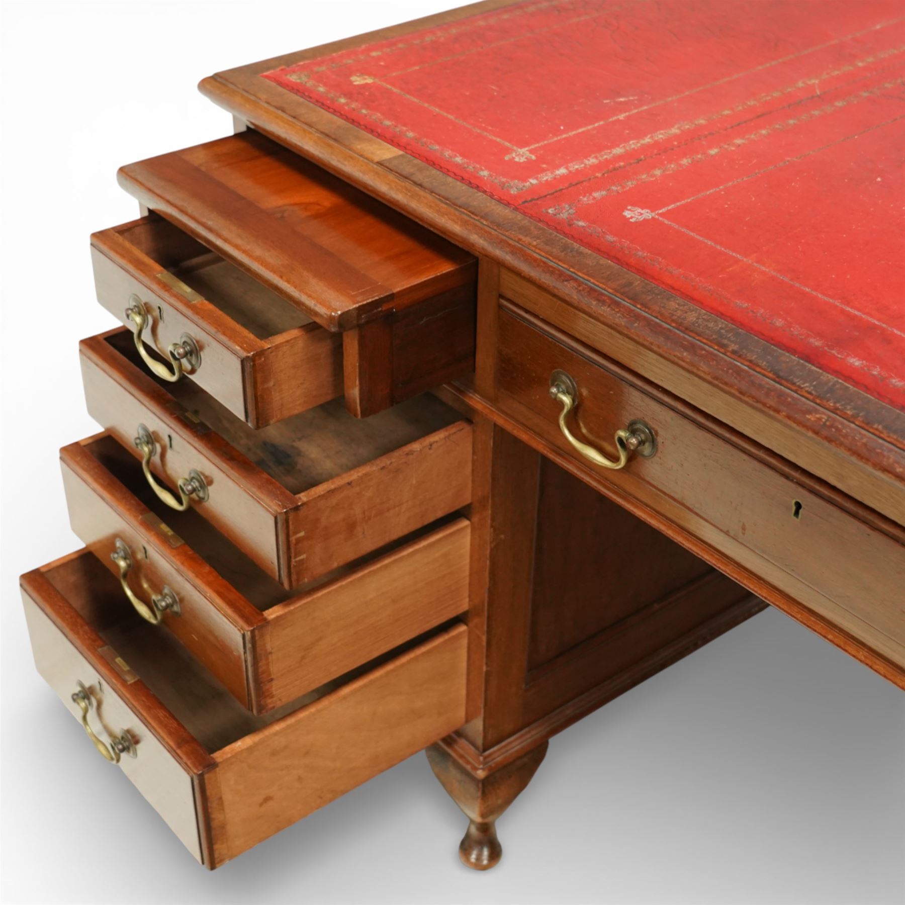 Late 19th century mahogany pedestal desk, rectangular top inset with worn red leather writing surface with gilt tooling, three frieze drawers above opposing pedestals each fitted with four graduated drawers, brass swan neck handles and escutcheons, panelled sides and back, raised on turned feet