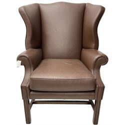 Georgian design wingback armchair, rolled arms over loose seat cushion, upholstered in chocolate brown leather, on square moulded supports united by H-stretcher