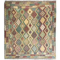 Anatolian Kilim cream ground rug, decorated with repeating diamond motifs in red, blue, yellow, and green, bordered by narrow bands of stylised geometric patterns in contrasting shades