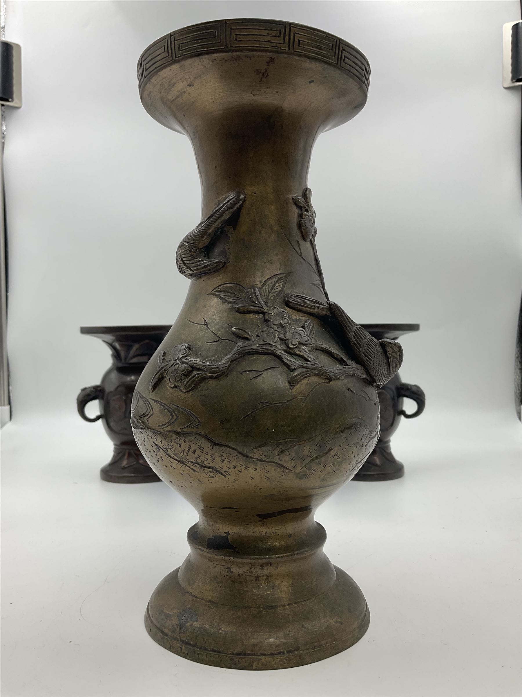 Chinese bronze vase, of baluster form with elongated neck, decorated in relief with birds amongst prunus blossom, together with a smaller pair of twin handled bronzed vases, decorated with peacocks and a blue Peking glass dish, with white metal mounted decorated with dragons, bronze vase H23.3cm