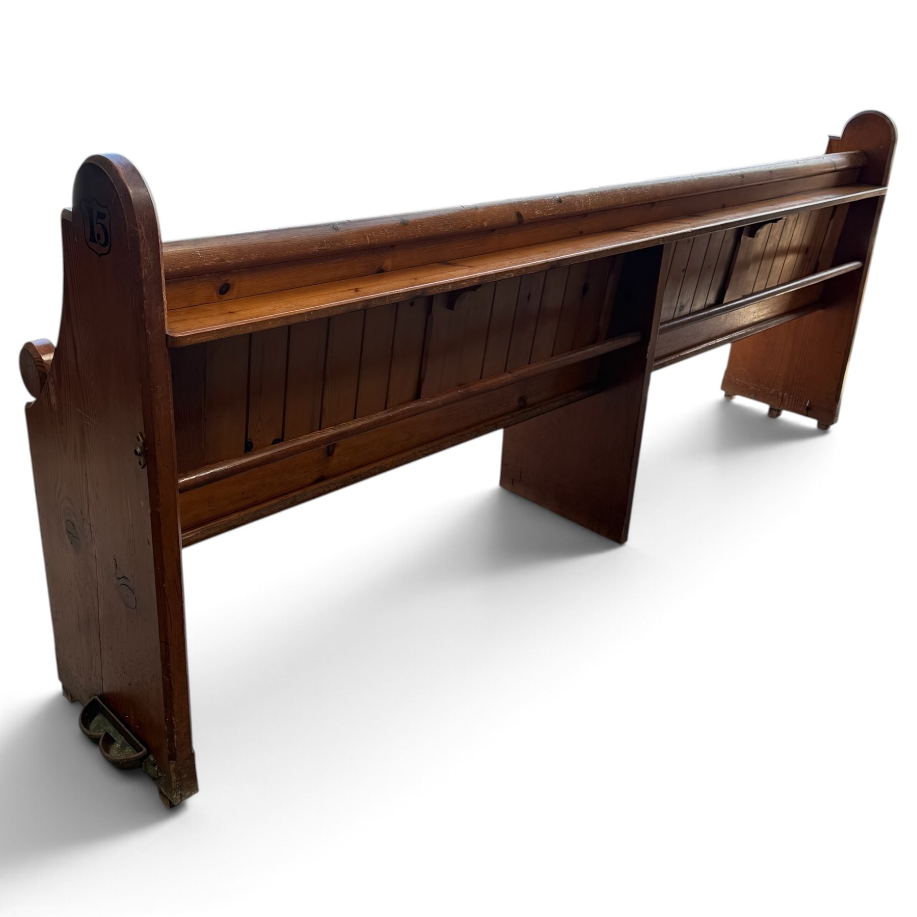 Early 20th century stained pine ecclesiastical church pew, the shaped end supports flanking slatted and panelled back, with black stencilled number '15' to the side
