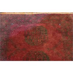 Antique Persian Bokhara red ground runner rug, repeating Gul pattern, surrounded by borders, with fringed ends