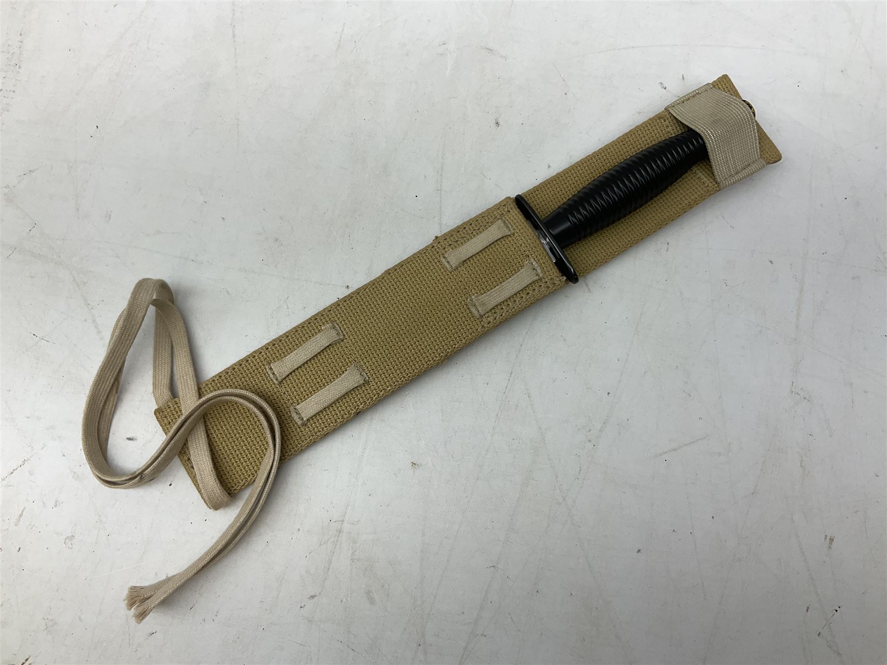 Gulf War period commando knife with 17cm double-edged steel blade etched with the crest and motto 'By Strength and Guile', blackened cross-piece and grip; in webbing scabbard L31cm overall