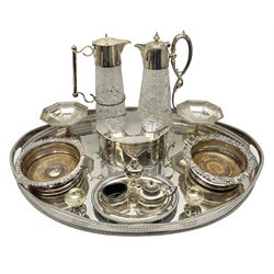 Pair of Mappin and Webb silver plate pierced pedestal bon bon dishes, together with other silver plate comprising teapot stand engraved with lion's head to centre, two cut glass claret jugs, two bottle coasters with acorn decoration, two open salts upon dolphin mounts, tea caddy, three piece cruet set and a large oval tray with pierced sides and upon four ball feet