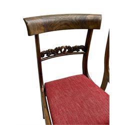 Set four Regency rosewood dining chairs, curved cresting rail over foliage scroll carved centre rail, upholstered drop in seats, on sabre front supports