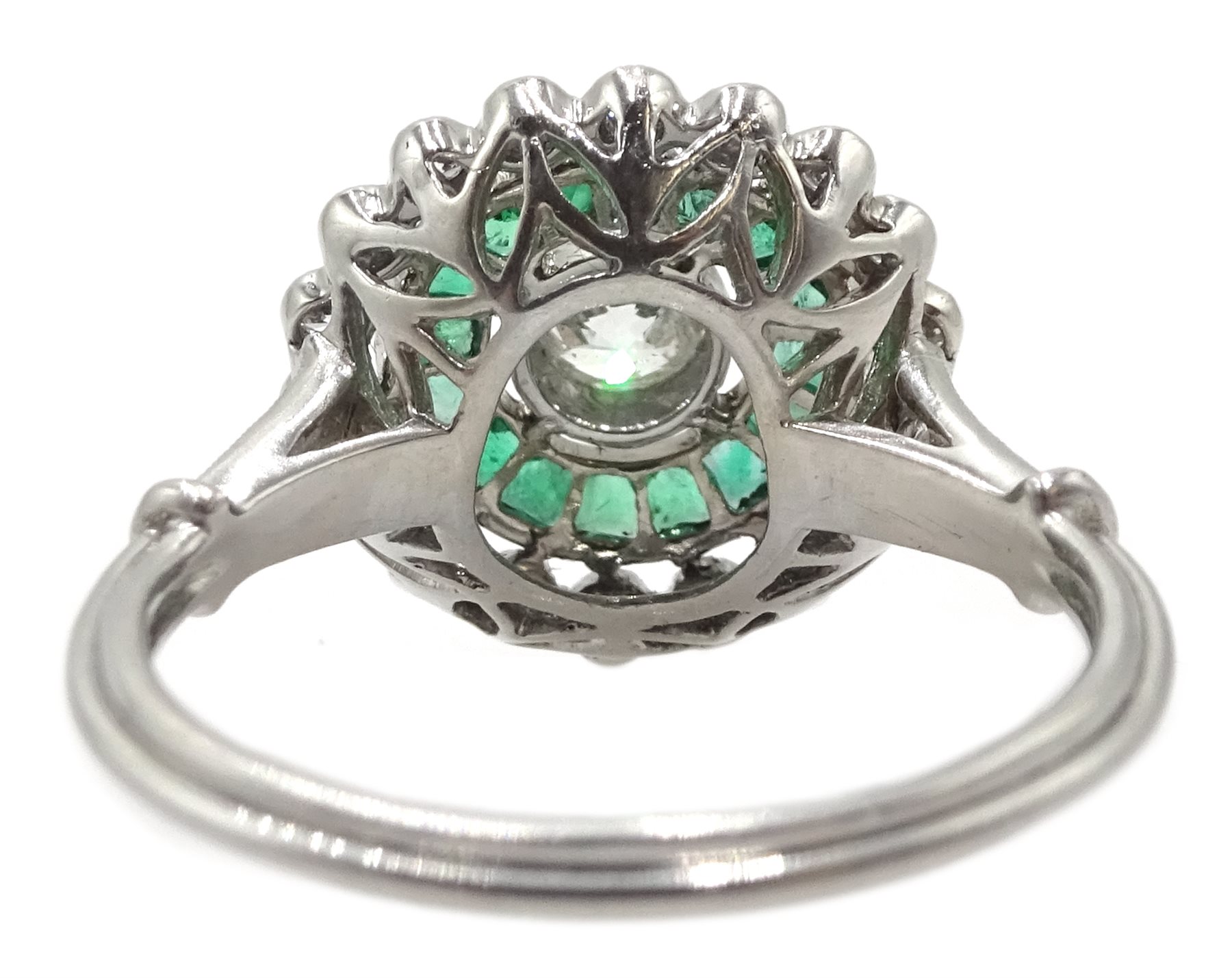Platinum round diamond and calibre cut emerald target design ring, with diamond set shoulders