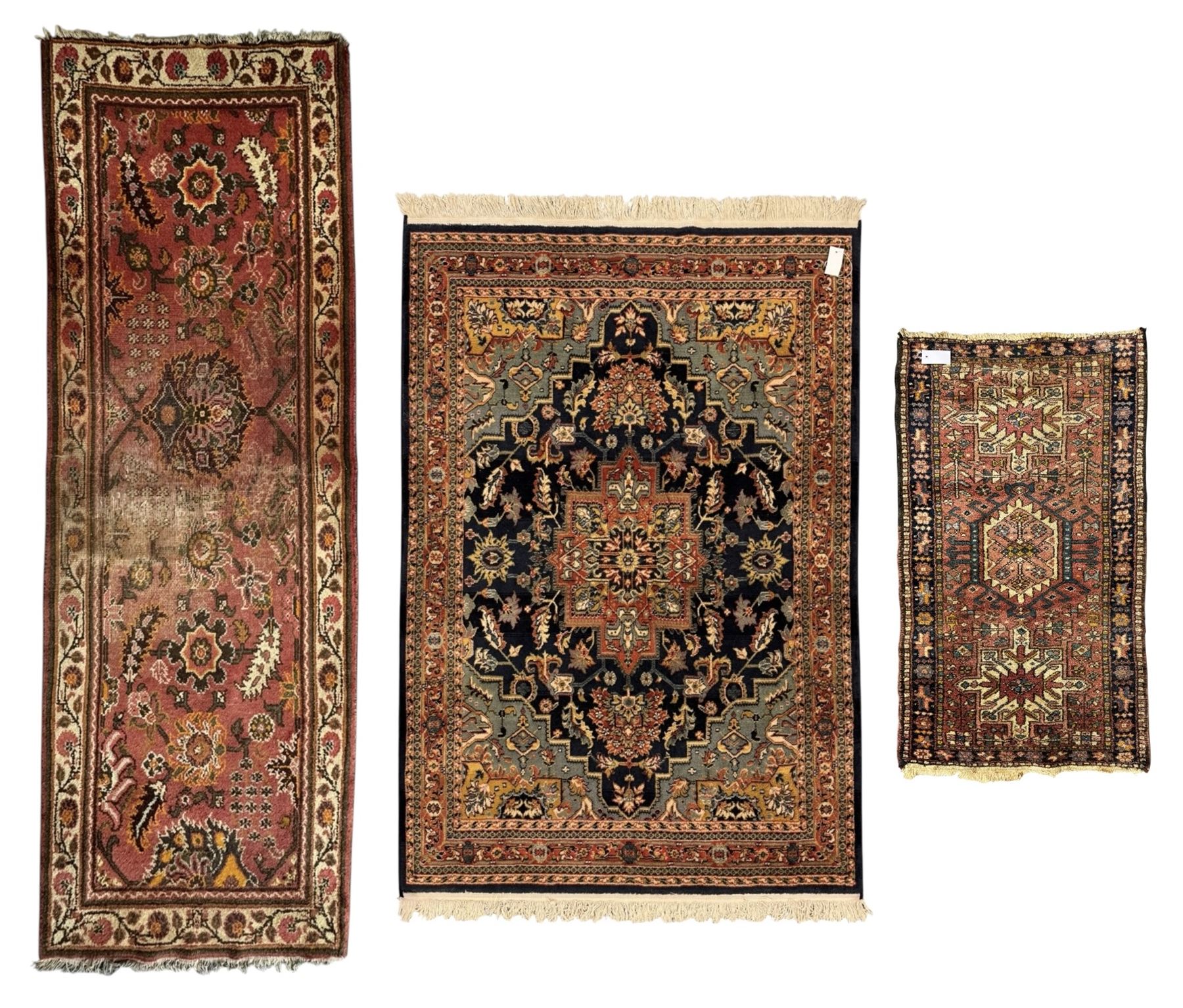 Belgian Sultan woollen ground rug, central navy field densely decorated with floral sprays and geometric patterns (192cm x 135cm); handwoven tribal terracotta ground rug (121cm x 71cm); Persian crimson ground runner, all over stylised floral and foliate motifs (266cm x 94cm)
