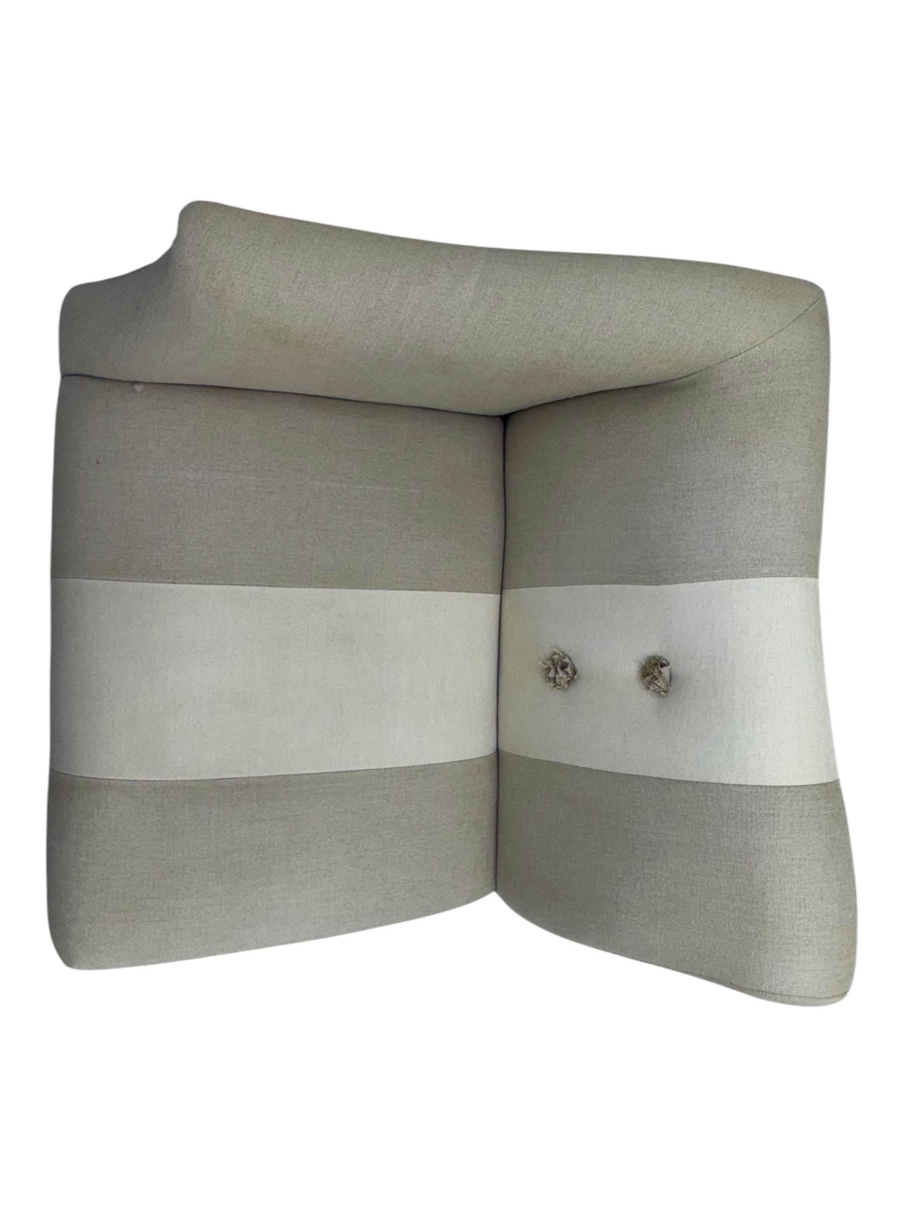 Pair of contemporary hardwood corner chairs, upholstered in broad alternating bands of neutral-toned fabric, each with two knotted rope buttons to the backrest, the whole raised on turned and lightly whitewashed supports terminating in castors