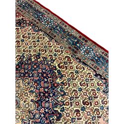 Persian Moud carpet, the field decorated all-over with Herati motifs, central medallion and spandrels decorated with stylised plant and flower head motifs, repeating border with guard
