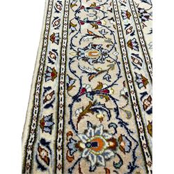 Persian Kashan ivory ground carpet, decorated all-over with interlacing foliate and stylised plant motifs, central scrolling medallion and matching spandrels, the guarded border decorated with repeating palmettes