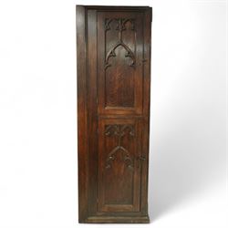 19th century Gothic Revival oak Sacristy vestment cupboard of tall proportions, fitted with two ecclesiastical trefoil moulded panelled doors enclosing four shelves, flanked by a chamfered corner, the side panelled and moulded with matching sacristic architectural mouldings, on skirted base