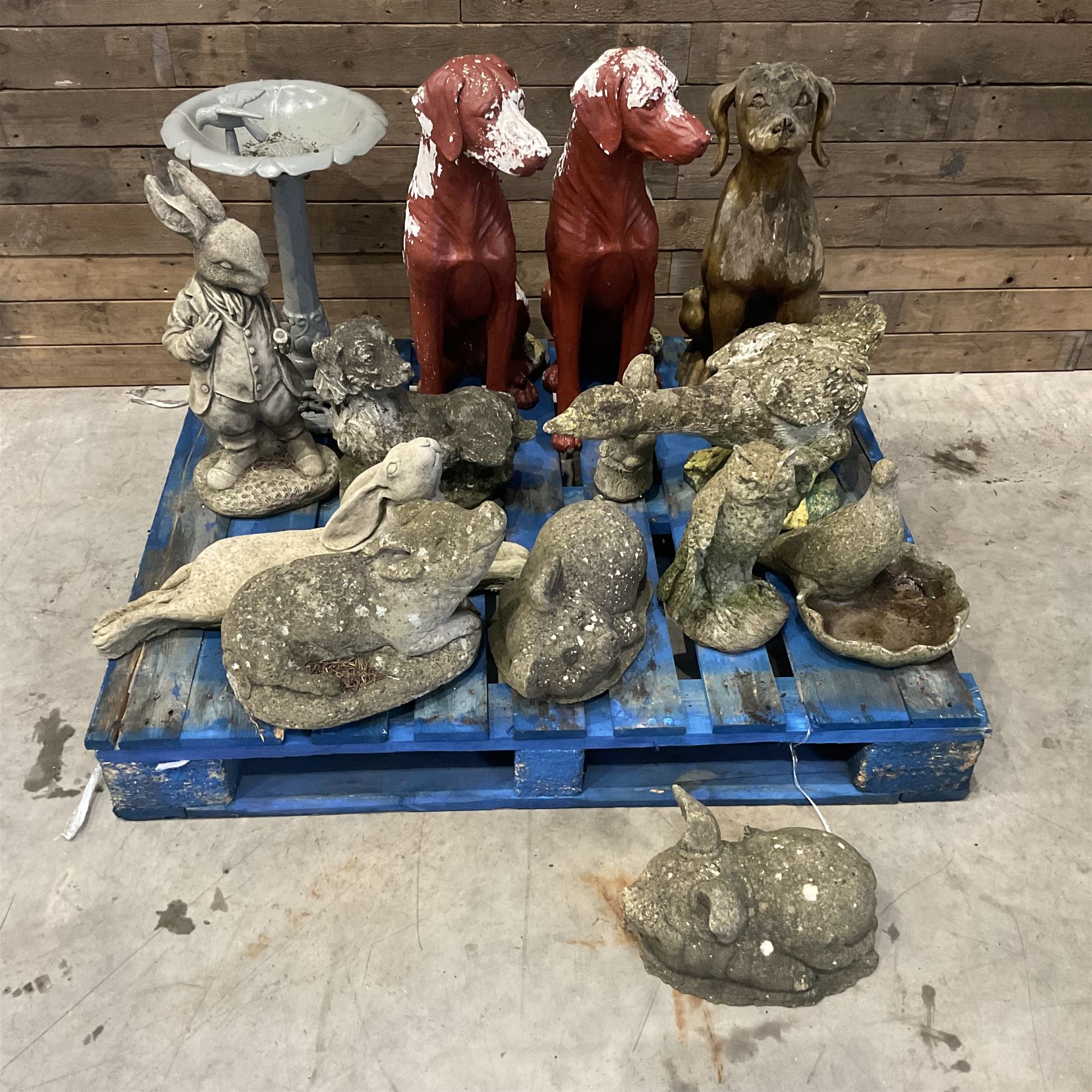 Various cast stone and composite garden ornaments, to include Peter Rabbit, goose, pigs, dogs, dog with wheelbarrow, painted metal bird bath and other, on two pallets