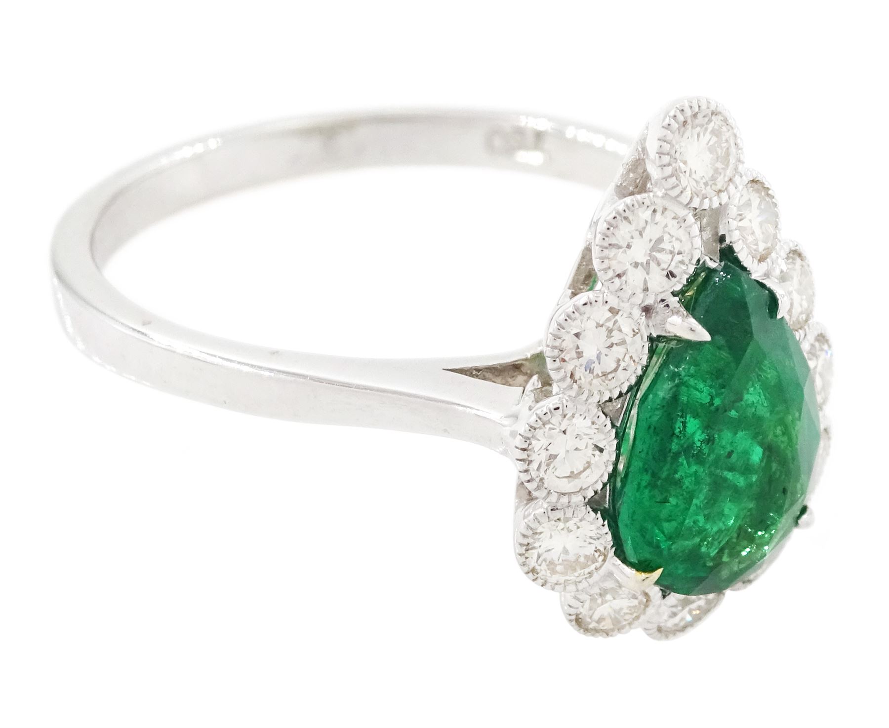 18ct white gold emerald and diamond cluster ring, single pear cut emerald of approx 1.40 carat, surrounded by twelve round brilliant cut diamonds, in a milgrain setting, stamped 750, total diamond weight approx 0.55 carat
