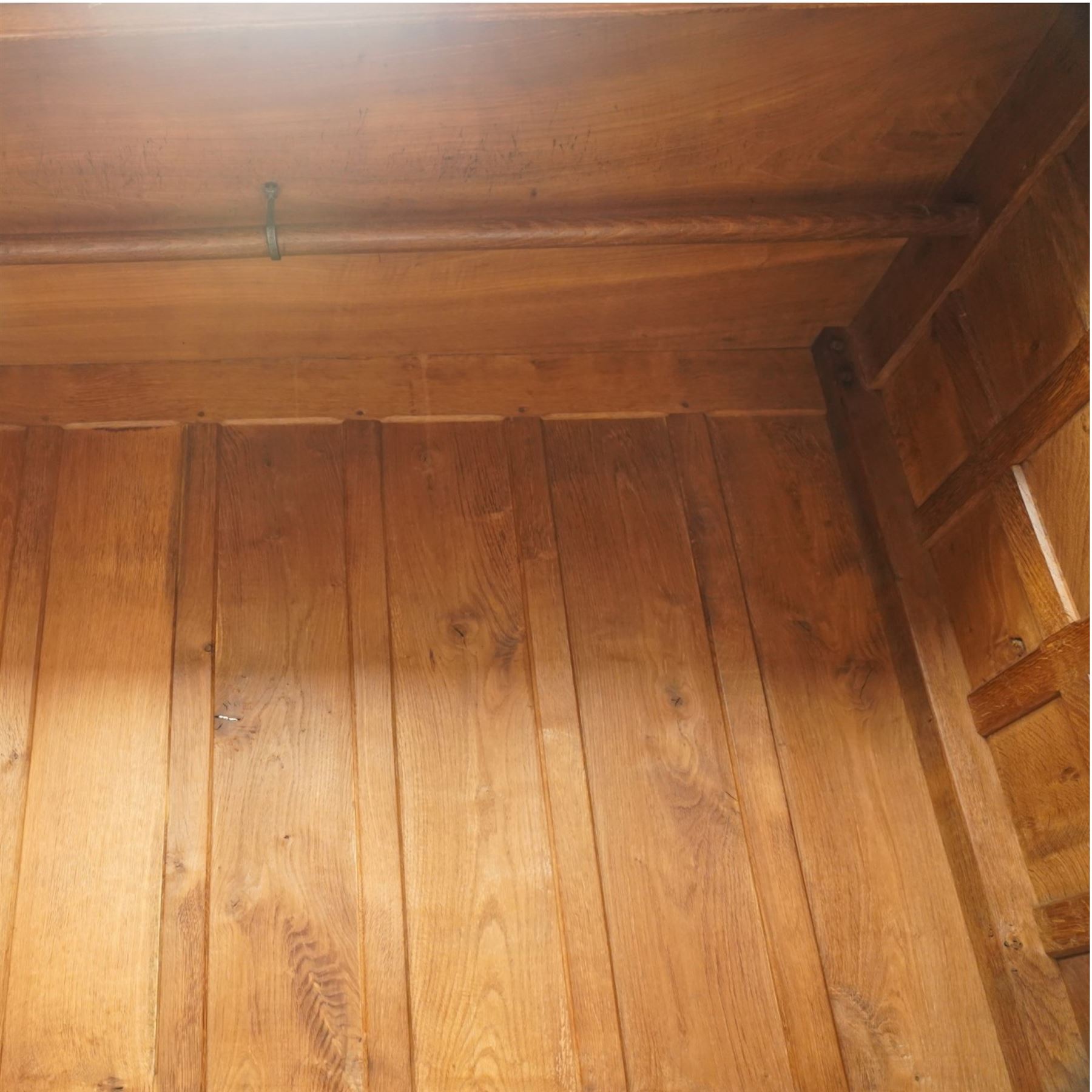 Mouseman - early-to-mid-20th century figured panelled and adzed double wardrobe of large proportions, the arcade carved cresting rail over two doors with adzed and figured oak panels, with wrought metal hinges and latch, relief carved mouse signature, the interior fitted with hanging rail, by the workshop of Robert Thompson, Kilburn