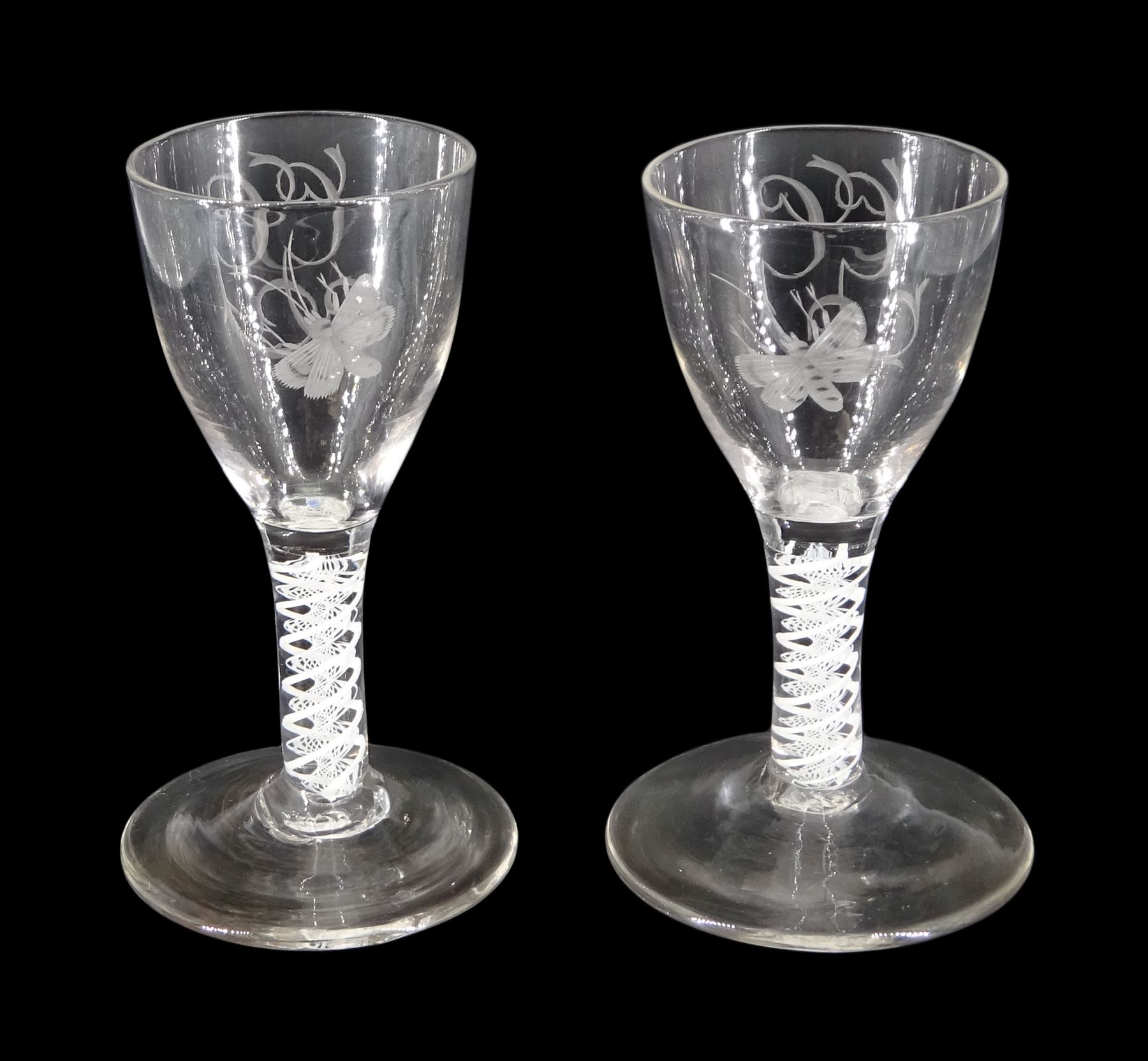 Pair of 18th century drinking glasses of possible Jacobite interest, the ogee bowls engraved with moth and initials 'G.G.', upon a double series opaque twist stems and conical feet, H12cm