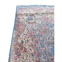 Large Persian design carpet, plain light blue field with floral design central medallion, scrolling foliate spandrels and borders decorated with flower heads