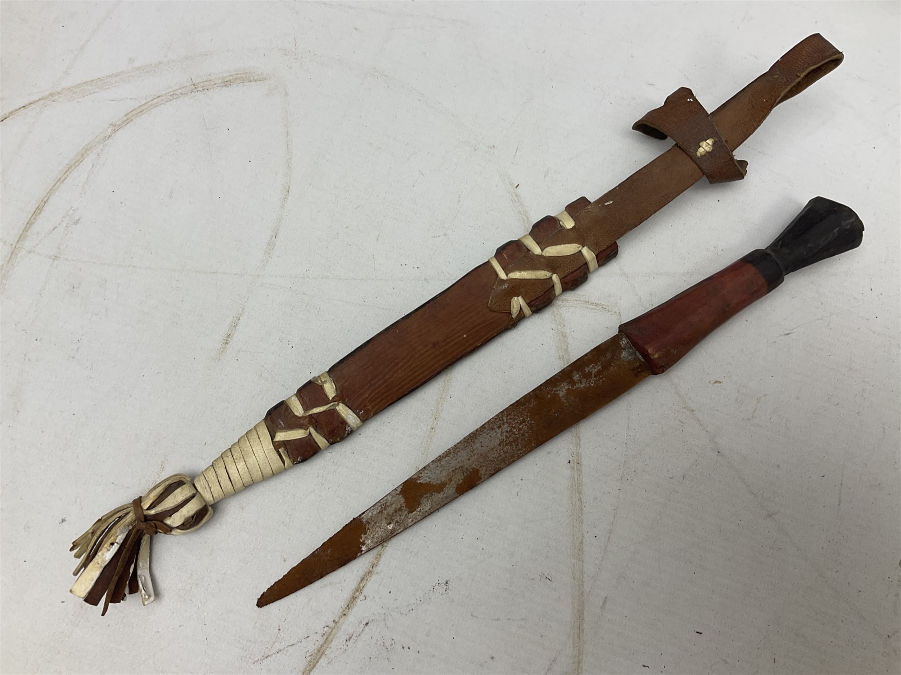 Indian kukri with 29cm curving steel blade and nickel mounted horn grip; in leather covered scabbard with one skinning knife L42cm overall; Hitler Youth knife with scabbard in relic condition; and three African graduated knives each with crudely carved wooden grips and painted leather covered scabbards (5)