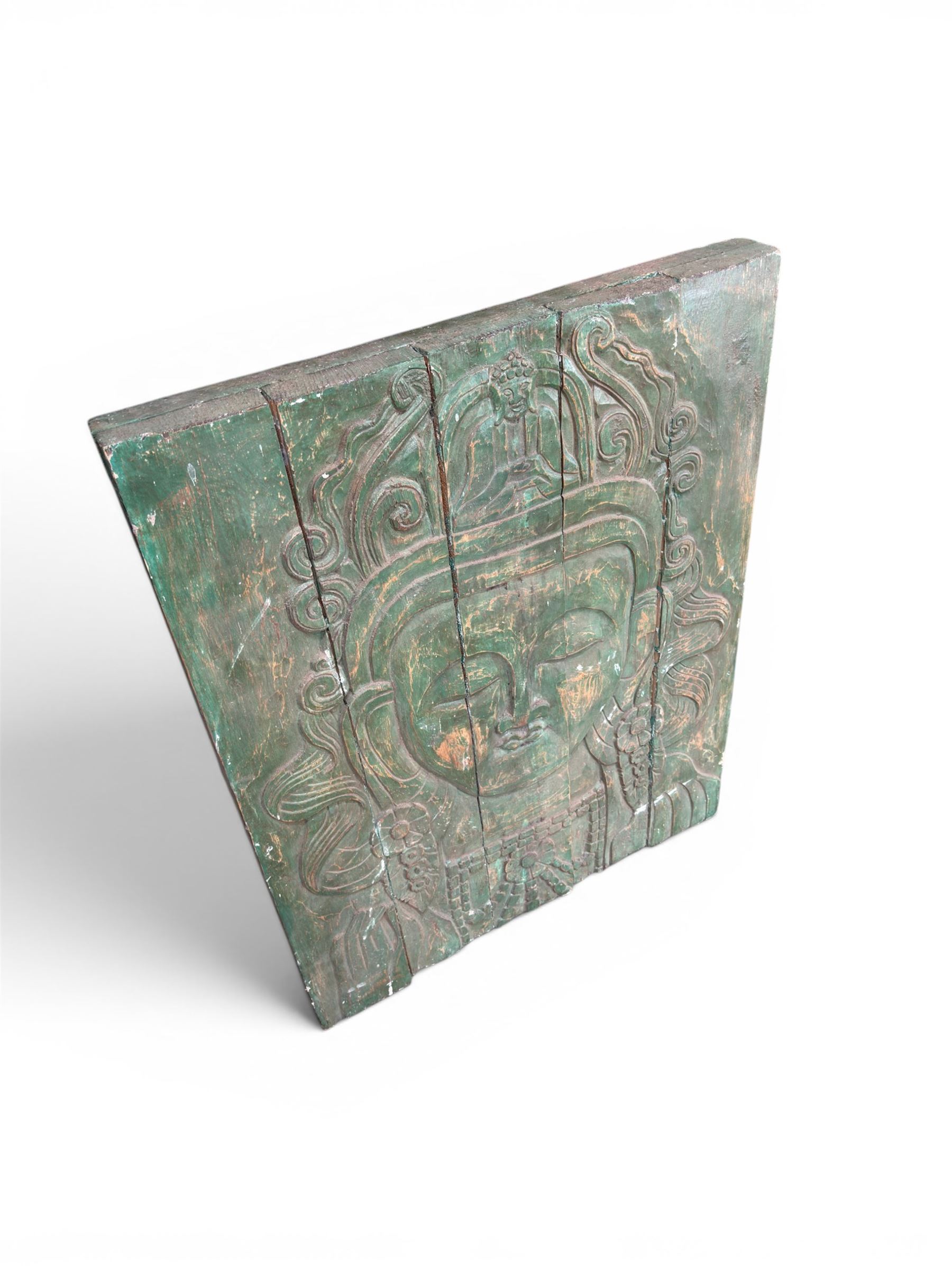 Pair of South East Asian carved wooden panels, depicting Buddha or Deity faces