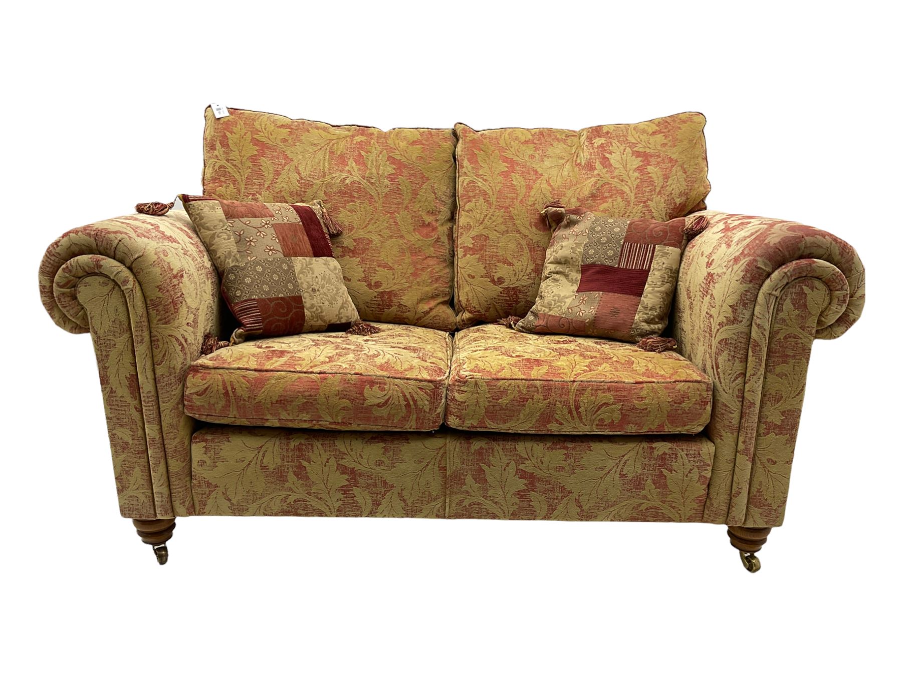 Duresta two seat sofa, upholstered in pale gold and rose fabric, mahogany feet; and matching rectangular footstool