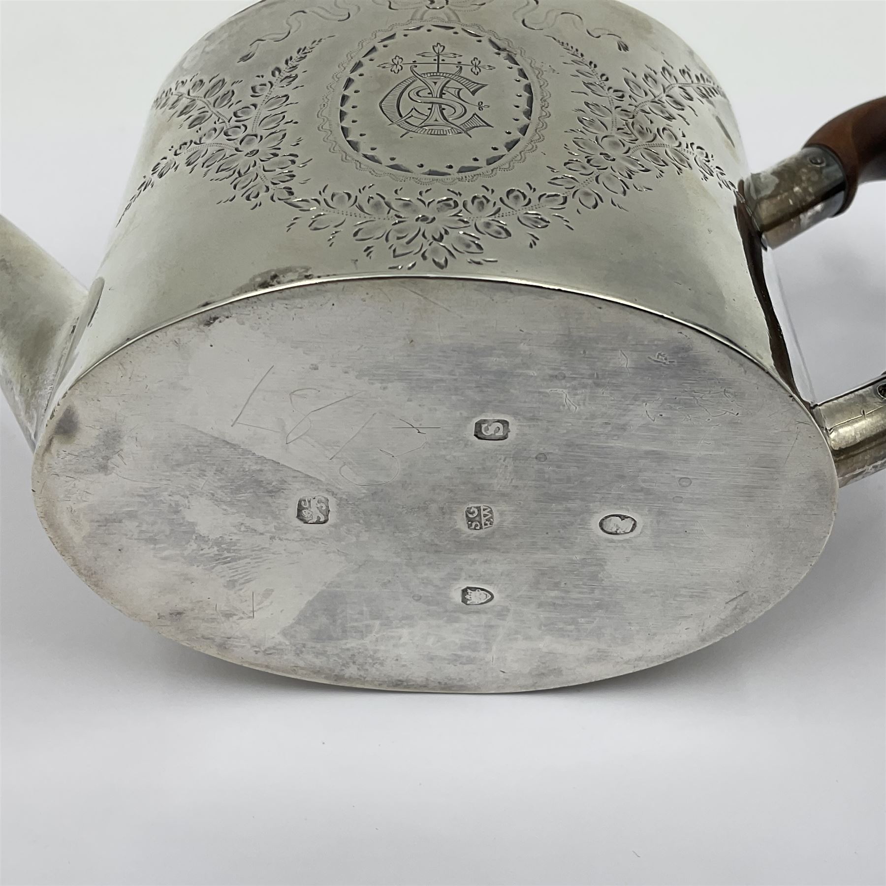 George III silver bachelors teapot, of oval form with wooden scroll handle and finial, the body chased with armorial crest and ribbon swag and foliate detail, hallmarked Samuel Godbehere & Edward Wigan, London 1793, including handle H9cm