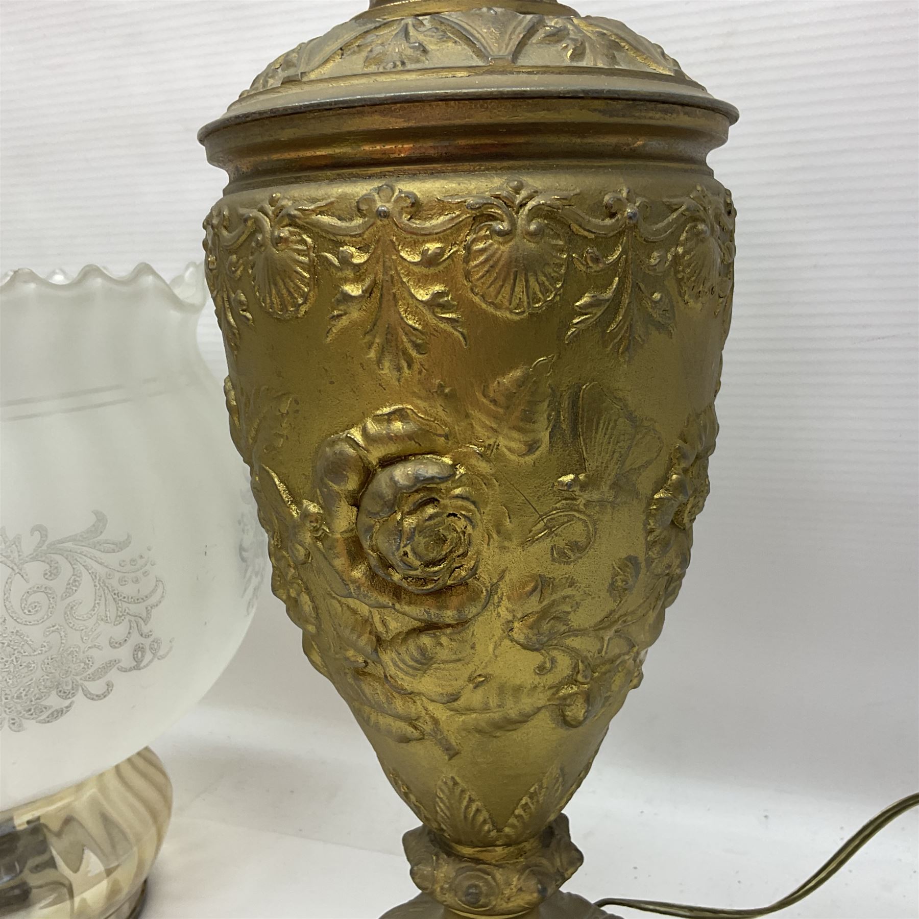Gilt metal table lamp, heavily embossed with flowers and butterflies, with fluted frosted glass shade, H56cm