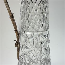 Silver plate mounted glass claret jug, the glass body of tapering form, the hinged lid a lion finial with shield shaped empty cartouche, the collar and spout cast with Bacchus face masks surrounded by grapes and vines, together with another silver plate mounted example, tallest H33cm