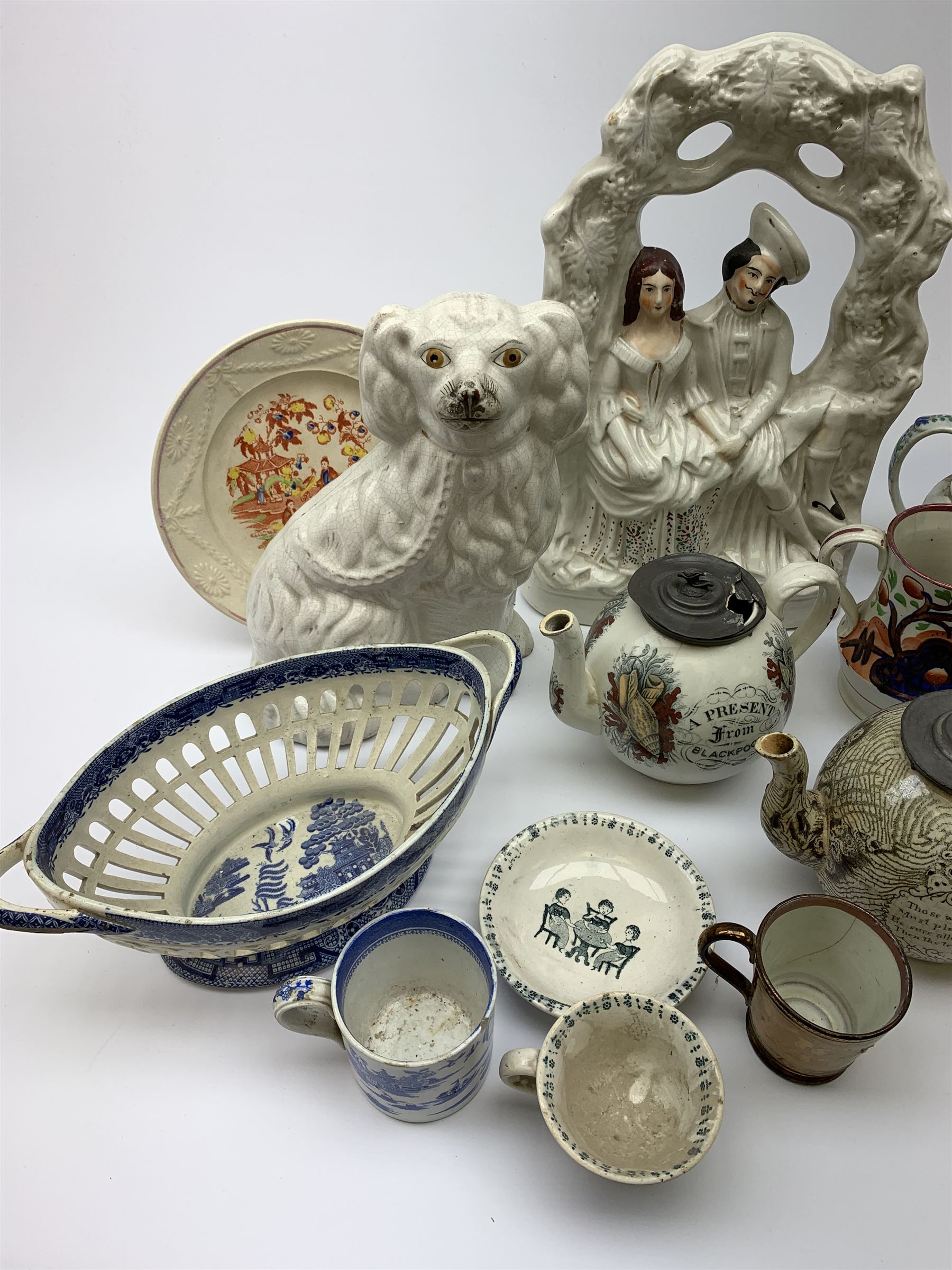 A group of 19th century ceramics, comprising agateware teapot with pewter cover, the body detailed with verse, a further example detailed A Present from Blackpool, large Wedgwood best composition mortar, two copper lustre jugs and a small cup, floral print decorated jug possibly Don Pottery, Gaudy Welsh jug, floral painted mug, Staffordshire nursery plate, teapot, and teacup and saucer, reticulated chestnut basket, Staffordshire bough group, plus a later Staffordshire style dog. (9). 