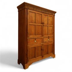 Victorian stripped pine kitchen cupboard, of rectangular form with fluted cornice and top section with two panelled cupboard doors revealing painted shelved interior, middle with two drawers with turned knob handles and brass cup handles, base section with two panelled cupboards, raised on shaped bracket feet 