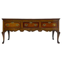18th century and later oak dresser base, the rectangular top with a moulded edge, fitted with three mahogany banded and cock-beaded drawers, the facias with brass handles and escutcheons, over a shaped apron with carved rail, raised on cabriole supports with foliate carved knees and pad feet
