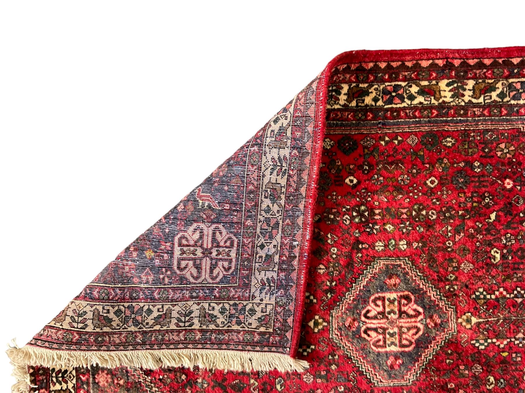 Persian Kashan crimson ground rug, hexagonal field decorated with central medallion and surrounding bird plant and animal motifs, guarded border with repeating floral and bird design