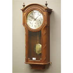  20th century walnut cased arched top wall clock with glazed door, silvered dial with triple train Elliot movement Westminster chiming  the quater hours, coil strike stamped 'LPS', H81cm  
