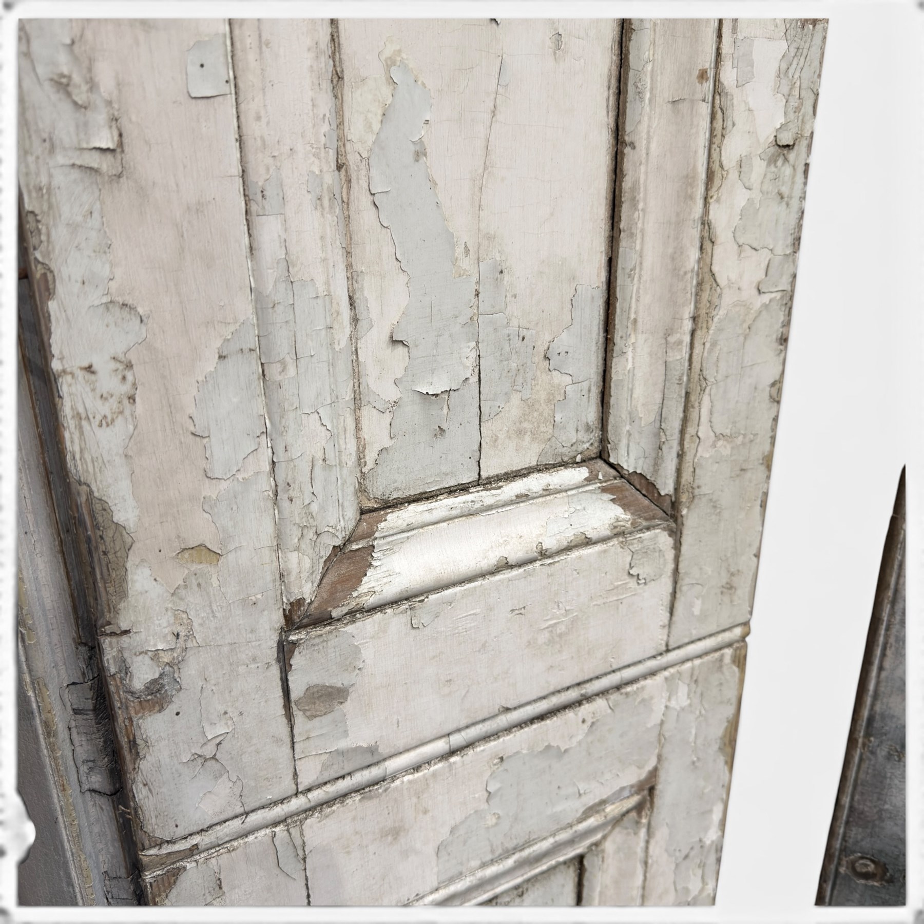 Set of three French 19th century painted pine folding window shutters of tall form, each comprising two hinged leaves with three graduated raised and fielded panels, in antique cream-painted finish