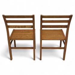 Treske of Thirsk - solid oak refectory dining suite, rectangular top with chamfered edge over trestle base united by a central stretcher, together with six matching slat back dining chairs, including two carvers, with panelled seats and square legs united by stretchers (H 87cm, W 62cm, D 57cm)
