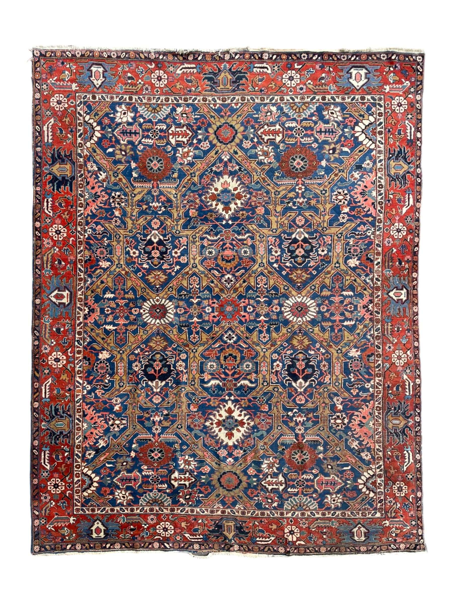 Persian blue ground carpet, the field divided up into panels by trailing bands with flower heads, each panel decorated with palmettes and stylised plant motifs, the border decorated with further palmettes, within floral pattern guard stripes 