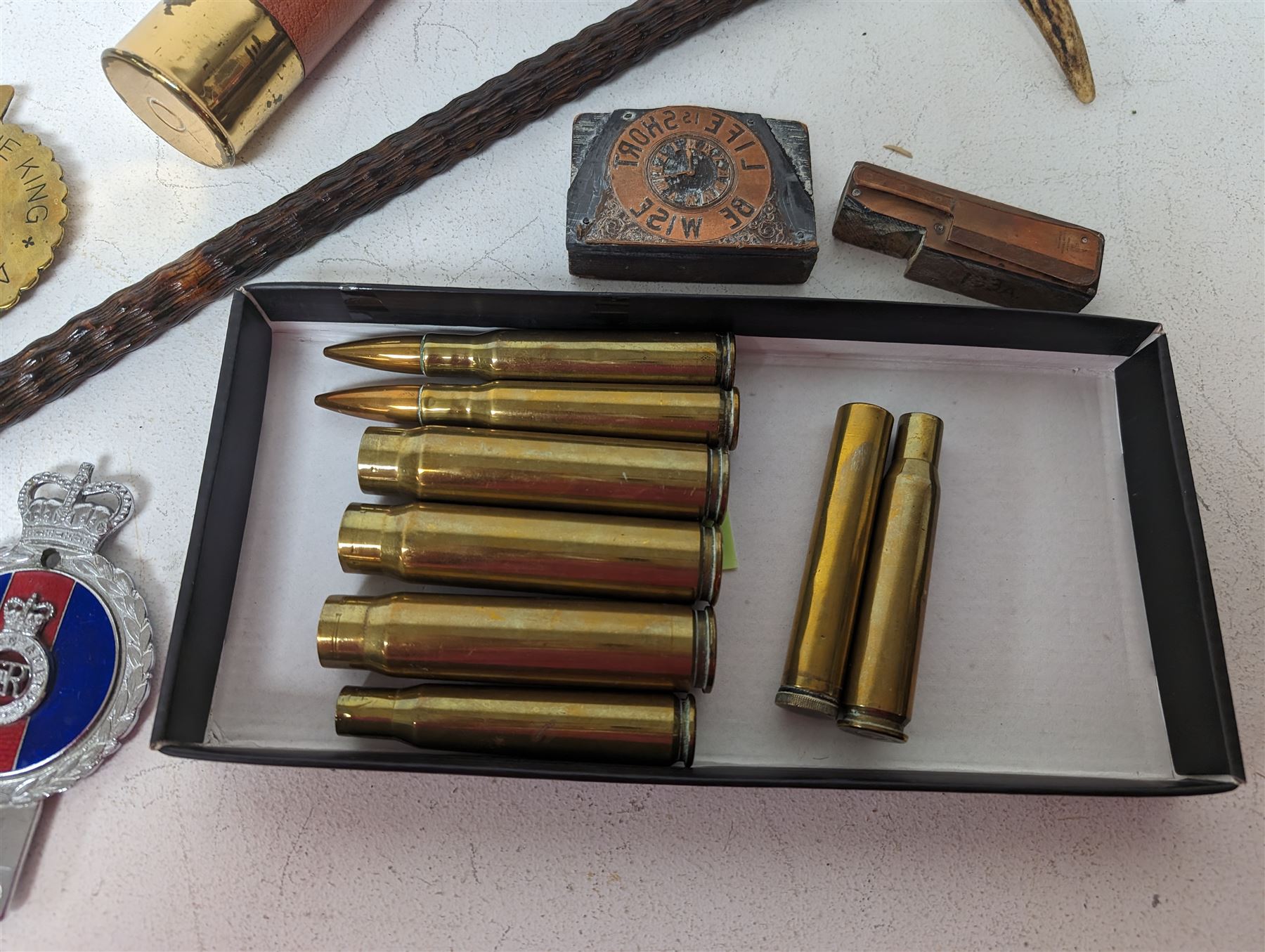 Walking stick with carved monkey handle, glass shooting flask in the form of a cartridge, bullet casings and other collectables