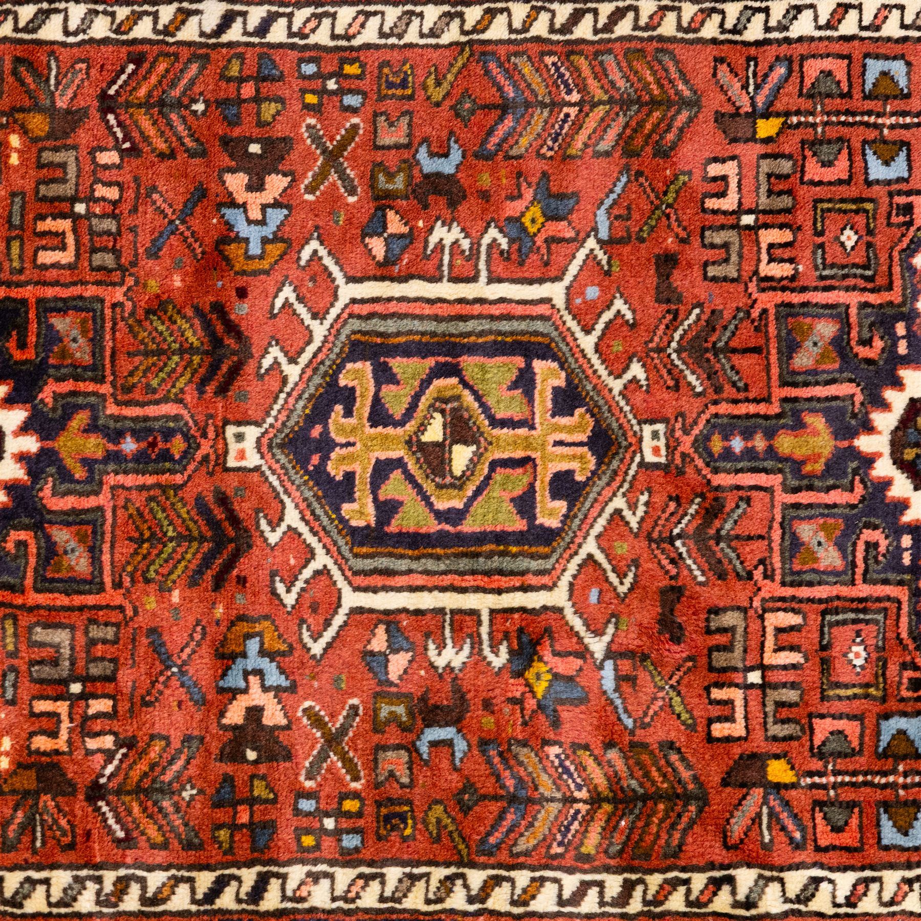 North West Persian Heriz hand-knotted runner, terracotta field decorated with a series of large angular medallions with stylized geometric motifs, surrounded stepped devices, and stylized trees within narrow geometric border, and polychromed edge, cotton fringe ends 
