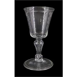 Early/mid 18th century drinking glass, the bucket shaped bowl upon a baluster stem with elongated tear, basal knop and folded conical foot, H14cm