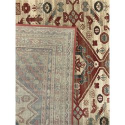 Persian design red ground rug, the field decorated with three interlinked lozenges and small stylised plant motifs, the multiple band border decorated with Boteh and floral motifs
