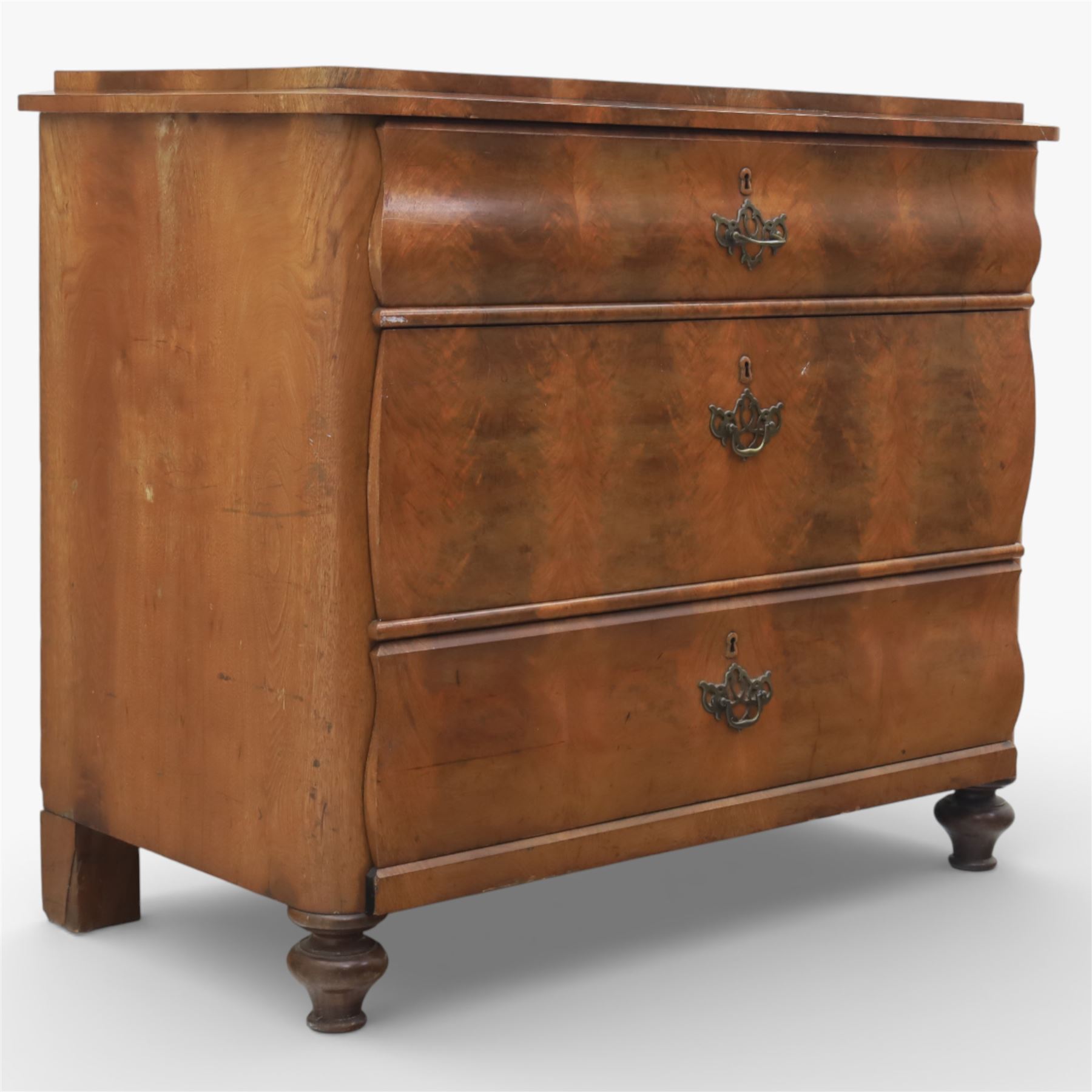 Late Victorian walnut and burr walnut chest of drawers, moulded top with rounded corners, finely figured burr walnut drawer fronts arranged as three long drawers, brass batwing handle plates, the lower section raised on turned bun feet