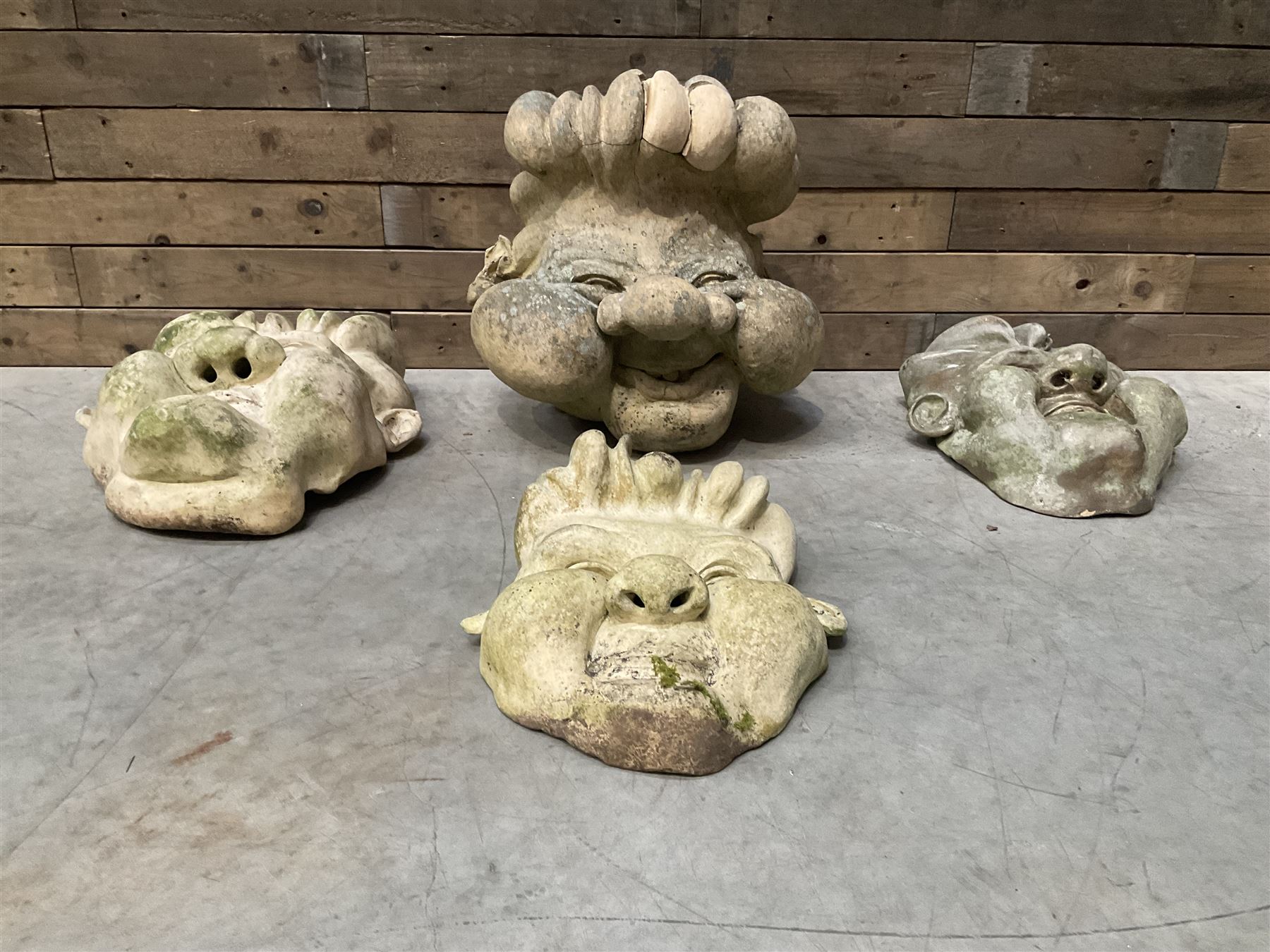 Four grotesque garden wall masks
