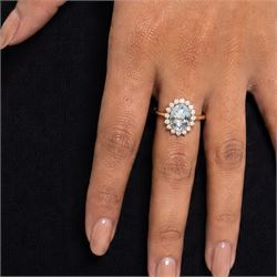 18ct gold aquamarine and diamond cluster ring, single oval cut aquamarine of approx 2.05 carat, surrounded by sixteen round brilliant cut diamonds, stamped, total diamond weight 0.40 carat